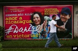 A man walks past a billboard promoting Nicaragua's President Daniel Ortega and running mate, his wife Rosario Murillo, in Managua, Nov. 5, 2016.