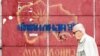 A man passes in front of graffiti with an old map of Macedonia referring to the long-running name row with neighboring Greece, in Skopje, June 13, 2018.