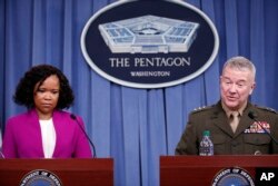 Kepala Juru Bicara Pentagon, Dana W. White (kiri), berdiri bersama Letnan Jenderal Angkatan Laut Kenneth F. McKenzie Jr., direktur, Staf Gabungan Militer AS, dalam briefing media di Pentagon, Washington, 14 April 2018.