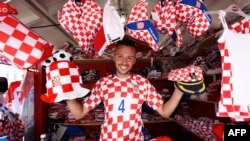 Un vendeur des souvenirs aux couleurs de l’équipe de la Croatie avant le match de football Coupe du monde Russie 2018 entre la Croatie et la Russie dans un stand sur la place principale de Zagreb le 7 juillet 2018.