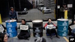 Para peserta unjuk rasa memblokir jalan masuk ke kantor Badan Penegakkan Imigrasi dan Bea Cukai, 28 Februari 2018, di San Francisco.
