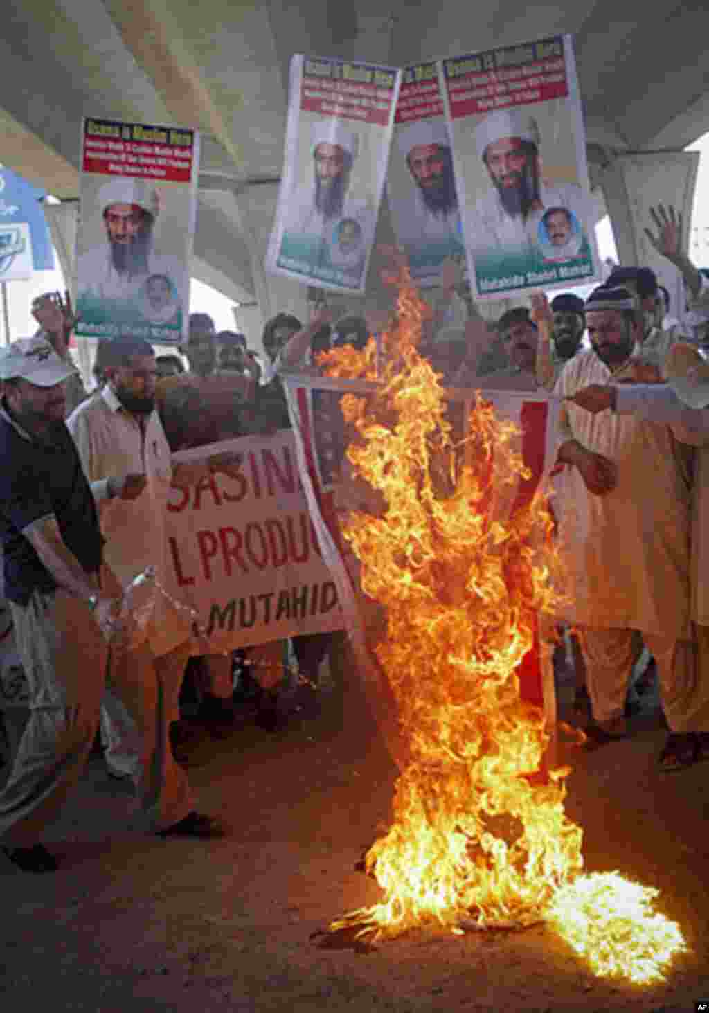 Dozens of activists from various organizations burn the United States flag while holding images of al-Qaida leader Osama bin Laden during an anti-U.S. rally in Multan, Pakistan May 6, 2011 (Reuters).