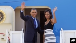 President Barack Obama and first lady Michelle Obama wave prior to boarding Air Force One before departing for a week-long trip to Senegal, South Africa, and Tanzania, June 26, 2013. 