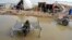 FILE - A woman, surrounded by floodwaters, sits near her belongings, in Sohbat Pur, Pakistan, Sep. 3, 2022. The flooding that year killed at least 1,700 people. The nation's weather officials reported on May 3, 2024, that Pakistan last month had its wettest April since 1961.