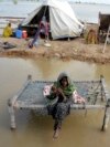 FILE - A woman, surrounded by floodwaters, sits near her belongings, in Sohbat Pur, Pakistan, Sep. 3, 2022. The flooding that year killed at least 1,700 people. The nation's weather officials reported on May 3, 2024, that Pakistan last month had its wettest April since 1961.
