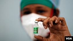 Una enfermera muestra un frasco de Covishield, la vacuna de AstraZeneca que será fabricada por el Instituto del Suero, en la India. [Archivo]