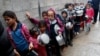 (FILE) Palestinian children wait in line to receive free meals in Gaza City, Feb. 4, 2021.