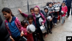 (FILE) Palestinian children wait in line to receive free meals in Gaza City, Feb. 4, 2021.