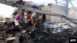 Yemeni men inspect damage at a factory allegedly targeted by Saudi-led coalition airstrikes in the Red Sea town of Hodeidah, July 27, 2018. 