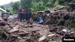 Warga berkumpul di lokasi tanah longsor di Nepal hari Minggu (13/9) (foto: tangkapan layar video Reuters).