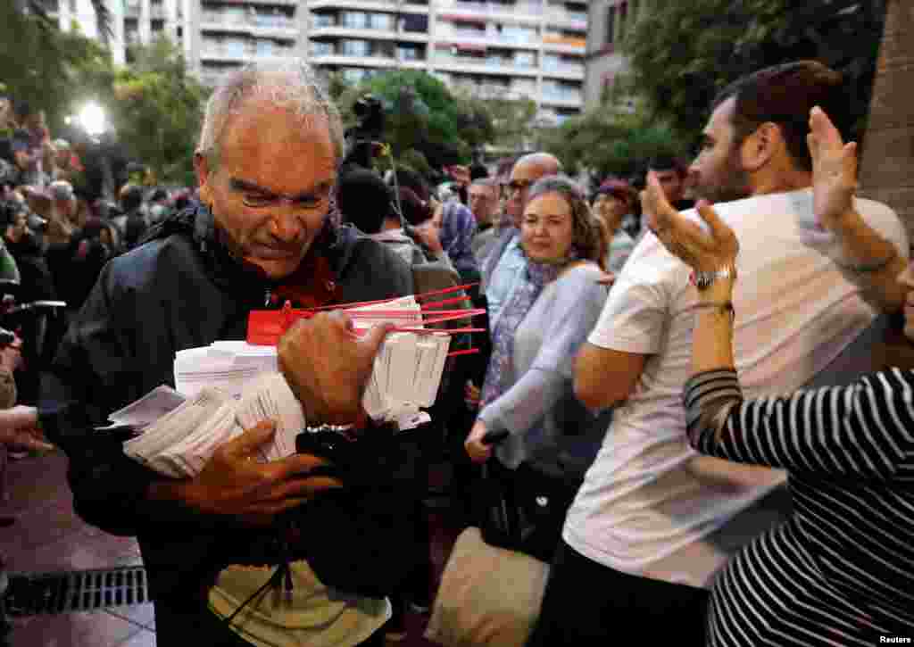 Un hombre sostiene las papeletas en una mesa de votación para el referéndum de independencia prohibido en Barcelona, ​​el 1 de octubre de 2017.