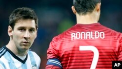 Lionel Messi de l'Argentine, à gauche, se tient à côté de Cristiano Ronaldo du Portugal avant un match amical international entre la sélection argentine et la portugaise à Old Trafford Stadium, Manchester, Angleterre, 18 novembre 2014. (AP Photo / Jon Super)