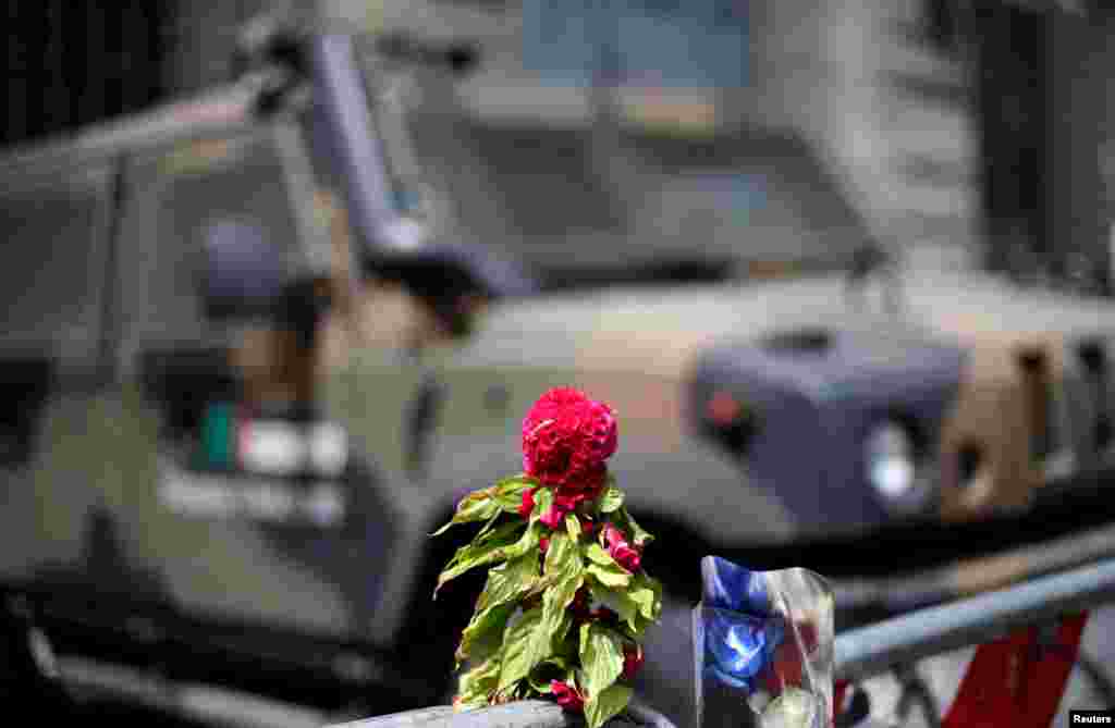 Flowers placed to pay tribute to the victims of the Bastille Day truck attack in Nice are seen in front of a military armored vehicle at the French embassy in Rome, Italy, July 15, 2016.