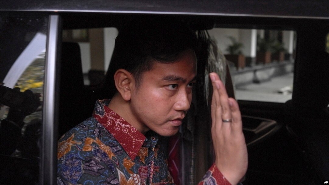 Wali Kota Solo dan cawapres nomor urut 2, Gibran Rakabuming Raka, menyapa para wartawan saat meninggalkan kantornya di Solo, Jawa Tengah, 23 Oktober 2023. (Foto: Hisyam Umar/AP Photo)