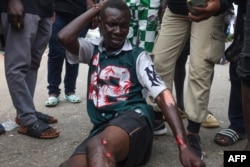 A protester lies looks astatine  his injuries pursuing  clashes with Nigerian information    forces during the End Bad Governance protestation  successful  Abuja, Aug. 2, 2024.