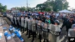 Policías forman un cordón afuera de la iglesia donde se celebra una misa por la libertad de los presos políticos, en Masaya, Nicaragua. Foto de archivo AP.