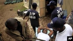 Volunteer health workers carry a pregnant woman to the hospital at a makeshift camp set up in the Petionville Golf Club in Port-au-Prince, 19 Mar 2010 (file photo)