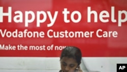 An employee talks on mobile phone inside a Vodafone store in Agartala, capital of India's northeastern state of Tripura, January 20, 2012. 