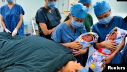 중국 사시성 시안의 한 병원에서 간호사들이 갓 태어난 쌍둥이 신생아를 산모에게 보여주고 있다. (자료사진)