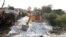 An excavator clears bags of white cement scattered on a road after a truck accident near Auraiya, a village in Uttar Pradesh state, India, May 16, 2020. 