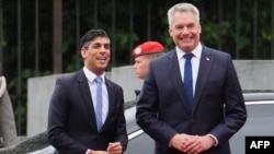 FILE—Austrian Chancellor Karl Nehammer (R) welcomes Britain's Prime Minister Rishi Sunak as he arrives for talks during an official visit to Austria, in Vienna, on May 21, 2024. 