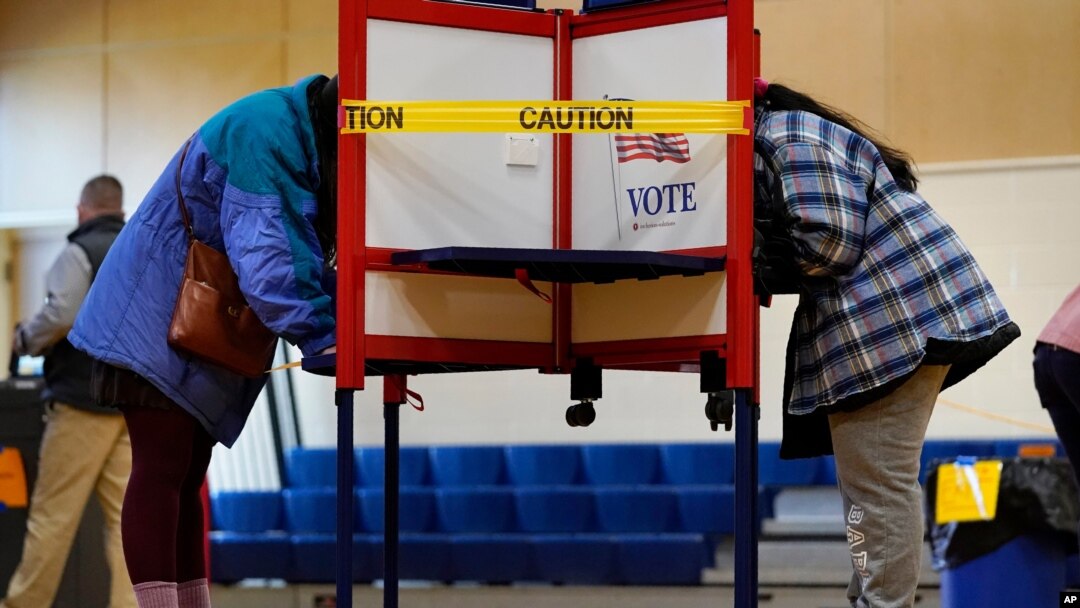 Caution tape closes off a voting stall to help distance voters to help prevent the spread of the coronavirus on Election Day, Nov. 3, 2020, in Portland, Maine.
