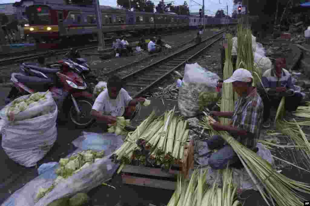 Para pedagang membuat ketupat untuk persiapan Idul Fitri, di Jakarta, 3 Juni 2019. (Foto: AP)