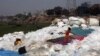 A girl plays with a toy gun at a plastics recycling yard in Dhaka, Bangladesh.