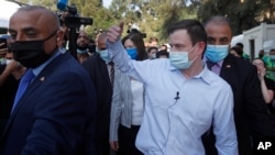 U.S. Undersecretary of State for Political Affairs David Hale, center, gives a thumbs up to volunteers as he visits the main gathering point for NGO volunteers, near the site of last week's explosion that hit the seaport of Beirut, Lebanon, Aug. 13, 2020.