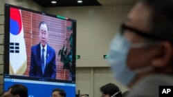 Chinese Foreign Minister Wang Yi, center, and attendees wearing face masks to help curb the spread of the coronavirus listen to a speech by former U.N. Secretary-General Ban Ki-moon Beijing, Sept. 28, 2020.