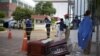 Orang-orang menunggu di sebelah peti mati di luar Rumah Sakit Umum Guasmo Sur setelah Ekuador melaporkan kasus corona di Guayaquil, Ekuador 1 April 2020. (Foto: Reuters/Vicente Gaibor del Pino)