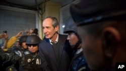 Former Guatemalan President Alvaro Colom is escorted by police to a courtroom in Guatemala City, Tuesday, Feb. 13, 2018. 