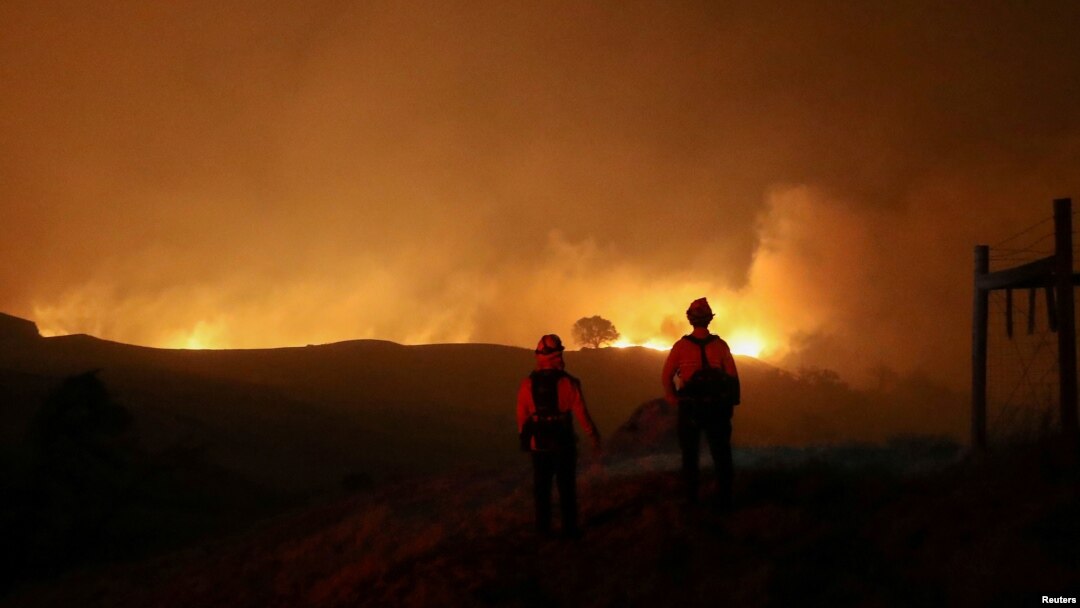 Dua petugas pemadam kebakaran memantau kebakaran Kincade, di dekat Geyserville, California, AS, 24 Oktober 2019.
