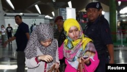 Family members of those onboard the missing Malaysia Airlines flight walk into the waiting area at Kuala Lumpur International Airport in Sepang March 8, 2014. 