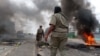 TOPSHOT - Mozambican security forces are seen next to a burning barricade in Maputo on December 24, 2024.