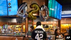 Customers gather around a counter to take advantage of special deals celebrating the 4/20 holiday at ShowGrow, a medical marijuana dispensary in downtown Los Angeles, April 20, 2017.