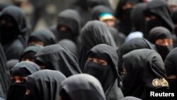 FILE - Black-clad women from the Akhdam (servants) community demonstrate to demand better rights and living conditions in Sanaa. The call for a ban on full face veils comes after Boko Haram has started using women as suicide bombers.