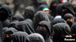 FILE - Black-clad women from the Akhdam (servants) community demonstrate to demand better rights and living conditions in Sanaa. The call for a ban on full face veils comes after Boko Haram has started using women as suicide bombers.