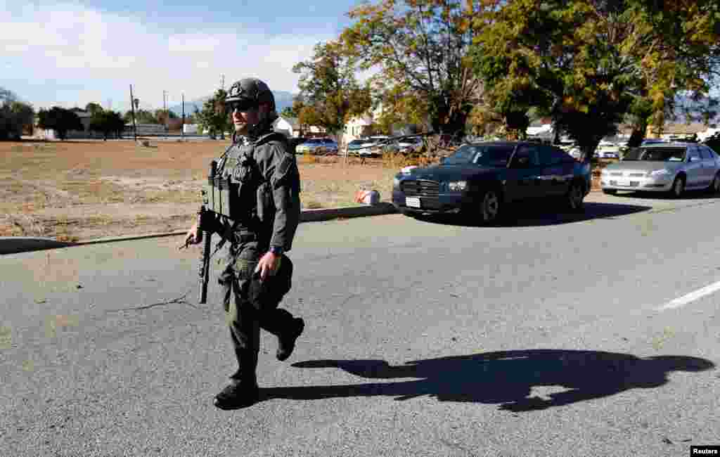 A law enforcement officer walks down a street near the scene. 