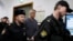Founder of the Baring Vostok investment fund Michael Calvey, center, is escorted to the courtroom in Moscow, Feb. 15, 2019. A veteran U.S. investment fund manager has been detained in Moscow and faces fraud charges.