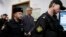 Founder of the Baring Vostok investment fund Michael Calvey, center, is escorted to the courtroom in Moscow, Feb. 15, 2019. A veteran U.S. investment fund manager has been detained in Moscow and faces fraud charges.