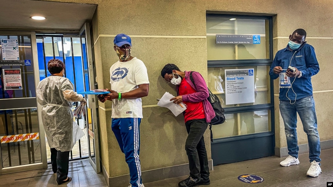 People who were just tested for COVID-19 wait in line to make payment for the test at a private laboratory in Johannesburg, South Africa, Dec. 19, 2020.