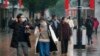 Masked pedestrians walk down a shopping street in downtown Wuhan, China, Wednesday, Jan. 22, 2020. The number of cases of a new coronavirus from Wuhan has risen over 400 in China and the death toll to 9, Chinese health authorities said.