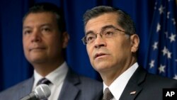 FILE - California Attorney General Xavier Becerra, right, flanked by Secretary of State Alex Padilla, speaks to reporters at the Capitol in Sacramento, Sept. 5, 2017. Becerra's lawsuit aimed at stopping the U.S.-Mexico border wall makes arguments similar to those made in a lawsuit brought last week by advocacy groups.