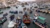 Pescadores van en procesión detrás de la representación de San Pedro, transportada en un bote, en el centro, como parte de la procesión por el océano Pacífico en honor del santo patrón católico de los pescadores en el día de su festividad en Pucusana, Perú, el jueves 29 de junio de 2023.