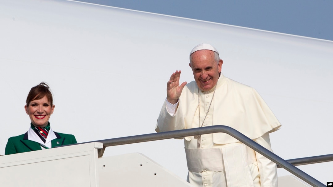 Paus Fransiskus melambaikan tangan ke arah wartawan di bandara internasional Fiumicino di Roma, Minggu (5/7) sebelum memasuki pesawat menuju Quito, Ecuador.