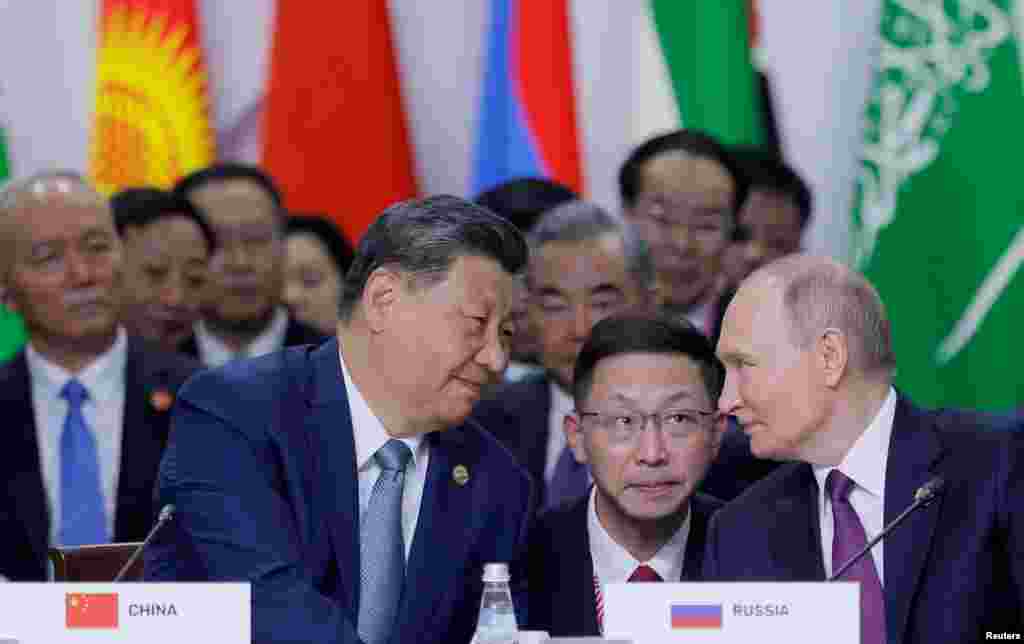 Russian President Vladimir Putin and Chinese President Xi Jinping speak during a plenary session in the outreach/BRICS Plus format at the BRICS summit in Kazan, Russia.