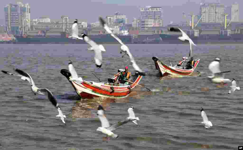 Seagulls fly over boats in the Rangoon river in Rangoon, Burma.