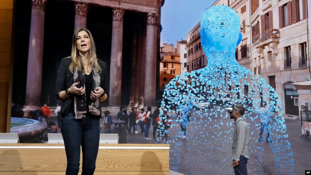 Megan Saunders, Microsoft's general manager, describes the capabilities of Paint 3D as Taj Reid experiences virtual reality at a Microsoft media event in New York, Oct. 26, 2016.
