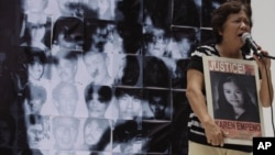 Mother of missing student activist Karen, speaks in front of a photo mosaic of Philippine President Benigno Aquino III during a rally to commemorate International Day of the Disappeared in Manila, Philippines, August 30, 2012.